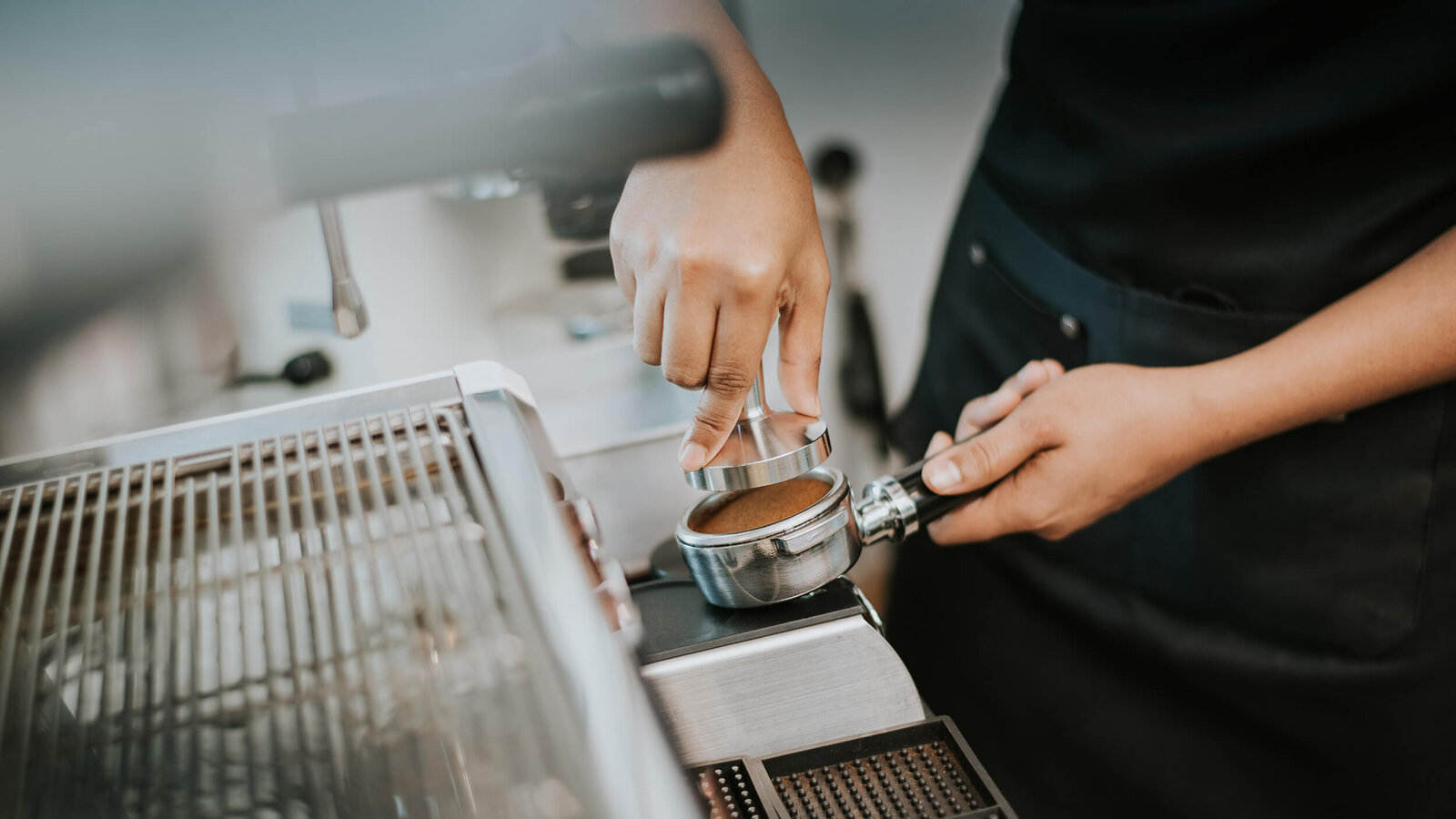 -Barista bereitet Kaffee vor mit einer Siebträgerportafilter und einer Espressomaschine.