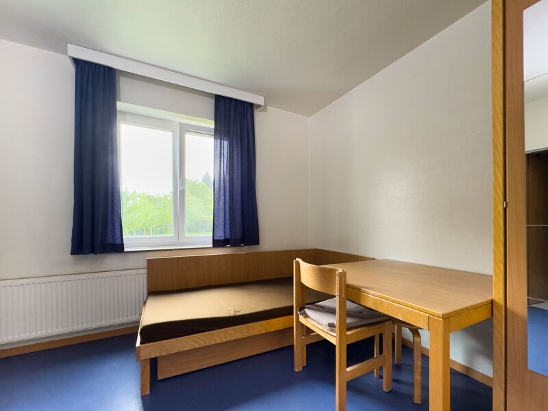 Mozartstrasse Apartment mit Bett, Tisch, Stuhl und Kleiderschrank
