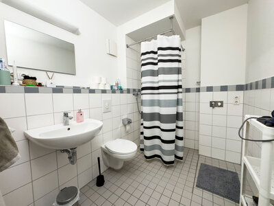 gefliestes Badezimmer mit bodentiefer Dusche