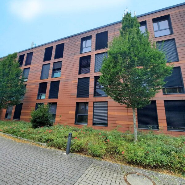 Fassade des modernen Gebäudes Schenkendorfstraße 129 mit Pflanzen und Fenstern.