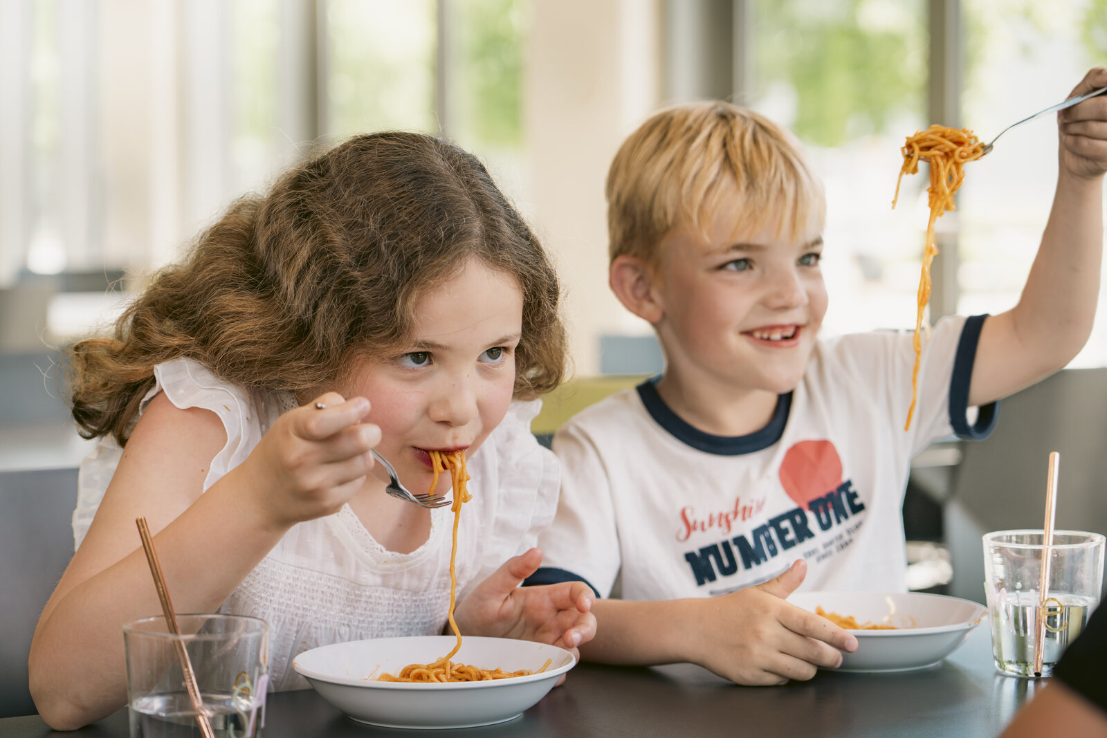 Kinder essen in der Schulmensa Spaghetti 