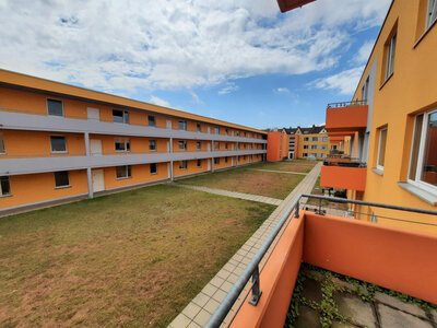 Blick auf Innenhof der Wohnanlage Arndtstraße 12–18 mit orangenem Anstrich und gepflasterten Wegen.