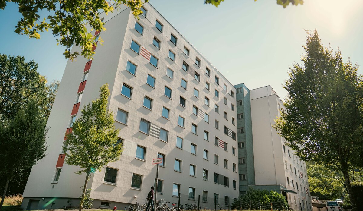 Wohnanlage "Wertherstraße 148" mit weißer Fassade, mehreren Fenstern und Grünflächen im Vordergrund.