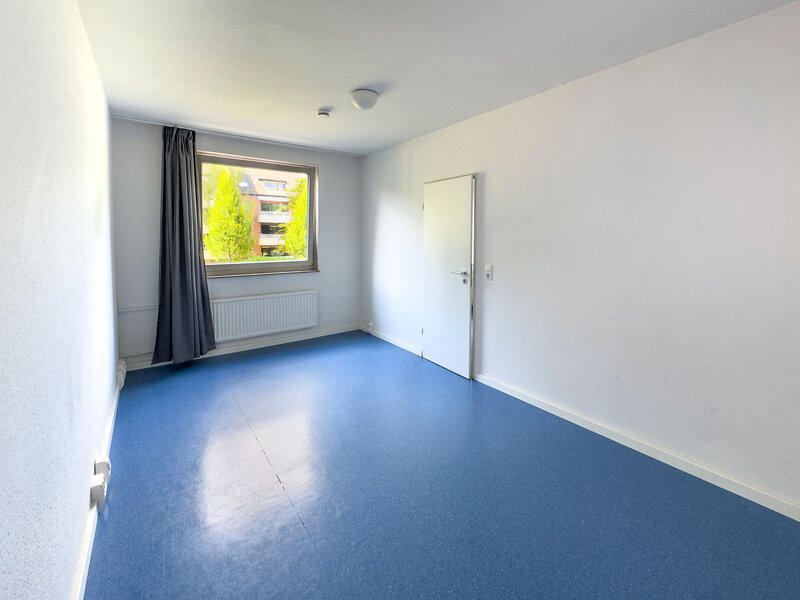 Helles leeres WG-Zimmer mit grossem Fenster und Vorhängen