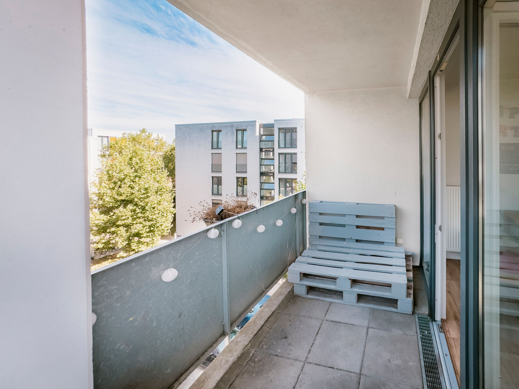 Balkon mit Sonnenausrichtung mit blauem Himmel und bodentiefen Fenstern