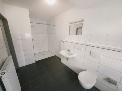 Badezimmer mit bodentiefer Dusche und gefliesten Wänden und Badewanne