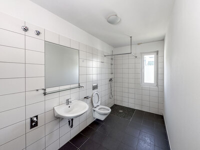 Helles gefliestes Badezimmer mit Spiegel und bodentiefer Dusche