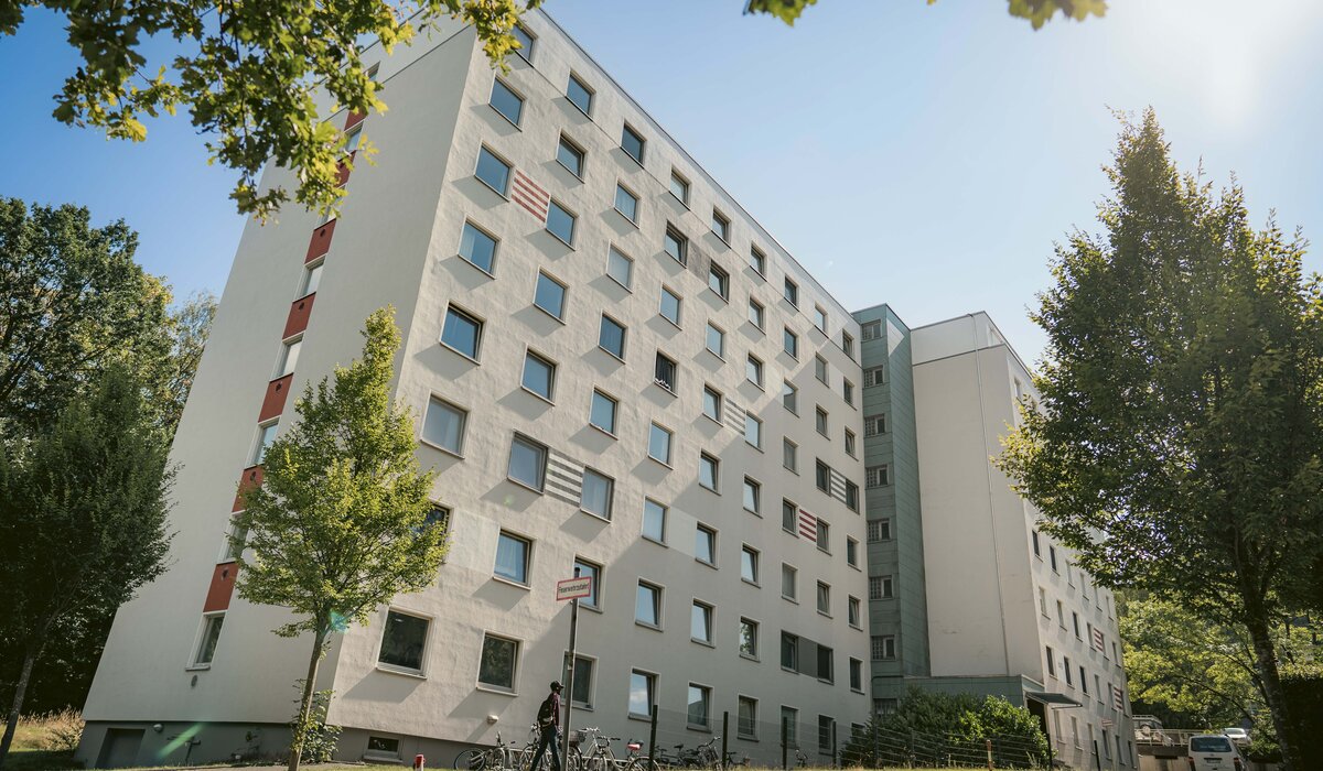 Wohnanlage "Wertherstraße 148" mit weißer Fassade, mehreren Fenstern und Grünflächen im Vordergrund.