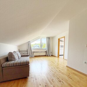 Helles Zimmer mit Sofa im Raum stehend.